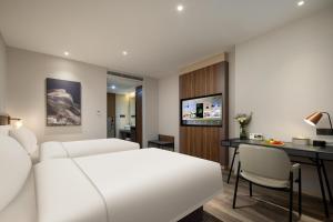 杭州杭州滨江火炬大道亚朵X酒店的一间酒店客房,配有一张白色的床和一张书桌