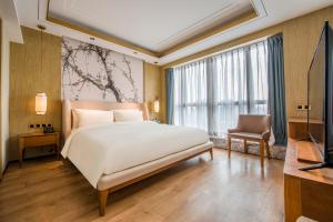 广州广州北京路天字码头亚朵S酒店的卧室配有一张白色大床和电视。