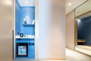 宁波宁波鄞州万达明州里亚朵酒店的一间设有蓝色墙壁和镜子的客房