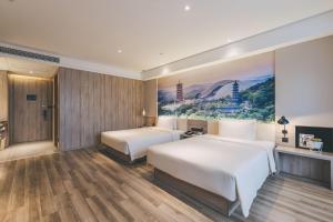 南京南京南站亚朵酒店的两张位于酒店客房的床,墙上挂着一幅画