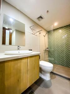 马尼拉Wesfame Suites的一间带水槽、卫生间和淋浴的浴室