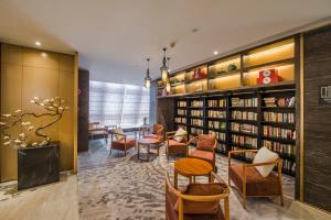广州广州北京路天字码头亚朵S酒店的图书馆配有桌椅和书架