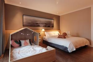 西归浦市套房酒店的一间卧室设有两张床,床上配有泰迪熊