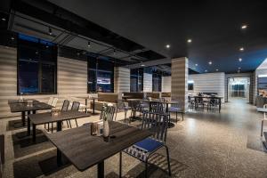 成都成都双流机场锦华路轻居酒店的餐厅设有木桌、椅子和窗户。