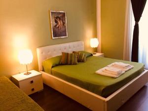 罗马亚历山大B&B酒店的一间卧室配有一张带绿床单的床和两盏灯。