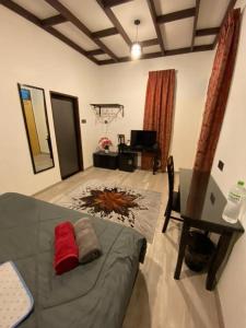 瓜拉丁加奴Maifa Village Chalet的一间卧室配有一张床、一张桌子和一张桌子