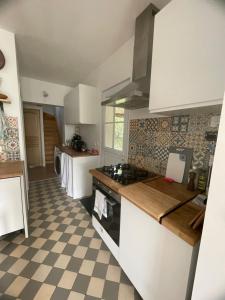 吉维尼Cosy Giverny的厨房配有白色橱柜和 ⁇ 格地板