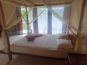 代尼耶耶Singheraja Lodge的一张位于带大窗户的房间内的床铺