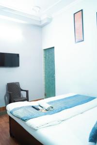 新德里Prince Reseidency Near Hari Nagar的一间卧室配有一张带椅子的床和一扇窗户