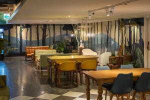 台北Finders Hotel-Fu Qian的一间设有桌椅的餐厅,墙上挂着壁画