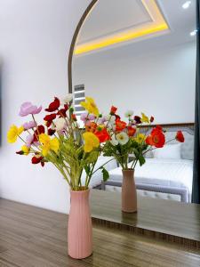 下龙湾Phượng Hoàng villa的两个花瓶,花在桌子上