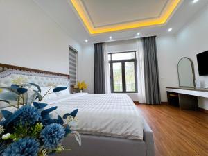 下龙湾Phượng Hoàng villa的一间卧室配有一张蓝色鲜花的大床