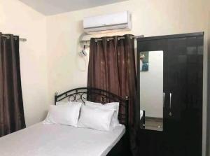 卡尔贾特BnBBuddy- Great Escape@Karjat, Maharashtra的卧室配有带白色枕头的床和窗户。