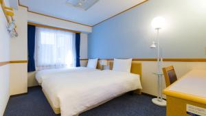 鹿儿岛Toyoko Inn Kagoshima chuo eki Higashi guchi的酒店客房设有两张床和窗户。