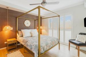 黄金海岸Bilinga Bliss - Luxury beachfront apartment的一间卧室配有一张天蓬床和一把椅子