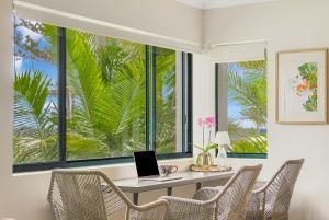 黄金海岸Bilinga Bliss - Luxury beachfront apartment的客房设有一张桌子,窗户前配有一台笔记本电脑