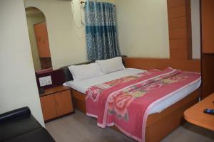 阿加尔塔拉Starline Hotel的一间小卧室,配有一张床和镜子