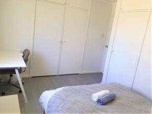 堪培拉Private Room in a Shared House-Close to City & ANU-4的一间设有白色橱柜、一张床和一张书桌的房间