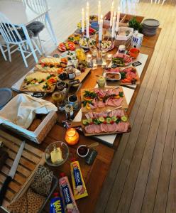 奇维克Kaptenshuset Hotell的一张长桌,上面放着许多盘子的食物和蜡烛