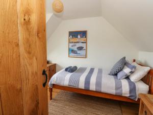 LochailortViking Cottage的一间卧室配有带条纹毯子的床
