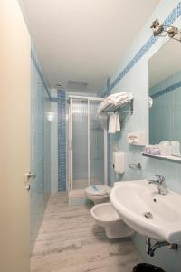 多尔梅莱托Hotel Le Palme的一间带两个盥洗盆和淋浴的浴室
