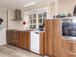 汉斯特霍尔姆Apartment Hanstholm的厨房配有木制橱柜和白色洗碗机。