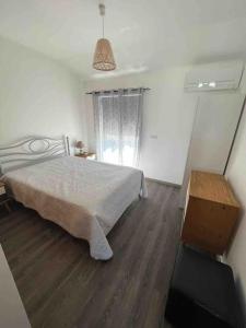 巴雷鲁Spacious House 3 Rooms的一间卧室配有一张床,铺有木地板