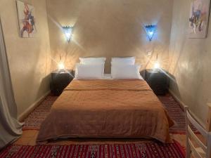 塔鲁丹特Hotel Riad Taroudant的一间卧室配有一张带两个灯的床