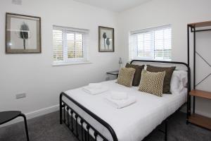 特尔福德Hartshorne House的一间卧室配有一张带两条白色毛巾的床