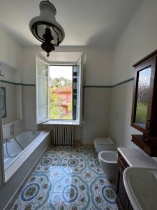 阿拉西奥Villa San Giorgio vista mare Alassio的带浴缸、两个卫生间和窗户的浴室