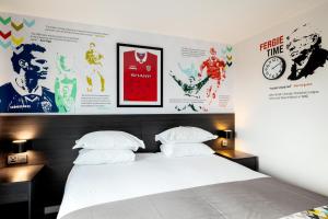 曼彻斯特Hotel Football, Old Trafford, a Tribute Portfolio Hotel的卧室配有一张床和墙上的海报