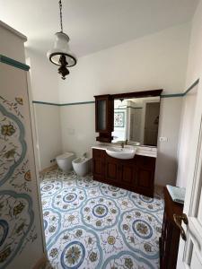 阿拉西奥Villa San Giorgio vista mare Alassio的一间带水槽、卫生间和镜子的浴室