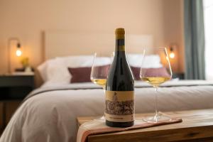 休拉纳Hotel Siuranella的一张桌子上放着一瓶葡萄酒,放上两杯