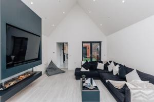 泰晤士河畔的多切斯特The Glass House的客厅配有黑色沙发和平面电视。