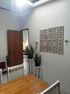 塔旺曼谷Argolawu Homestay的一间餐桌和墙上一些植物的用餐室