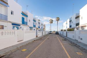 奇皮奥纳El Paseo del Faro的一条空的街道,有白色的建筑和棕榈树