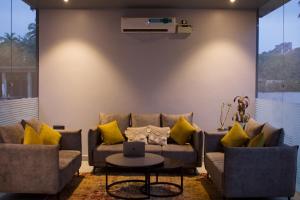 莫尔吉姆FabHotel Resort De Ashvem的带沙发和黄色枕头的客厅
