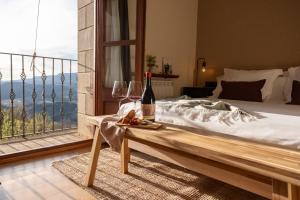 休拉纳Hotel Siuranella的一间卧室配有一张床,提供一瓶葡萄酒和玻璃杯