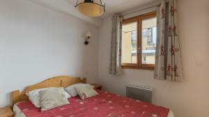 奥尔西埃B203- Appartement 2 pieces cabine 6 personnes的一间卧室配有一张带红色毯子的床和窗户。