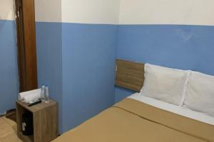 雅加达Bright Batavia的一间卧室配有一张蓝色墙壁的床