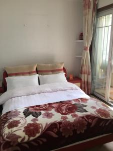 南京雅伦之屋 Yailon Aparment的一间卧室配有一张带花卉床罩的床