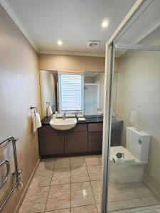 惠灵顿Executive, Spacious & Modern Home, 8 Beds!的一间带水槽和卫生间的浴室以及窗户。