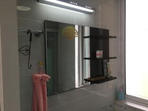 南京雅伦之屋 Yailon Aparment的浴室内的镜子和粉红色毛巾
