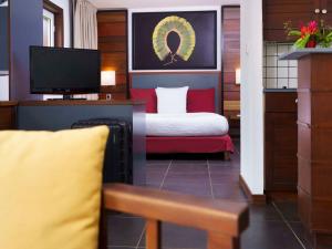 库鲁Hotel Mercure Kourou Ariatel的酒店客房,配有床和电视