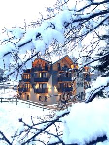 梅扎纳皮兹奥特住宅酒店的一座有灯光的雪地建筑