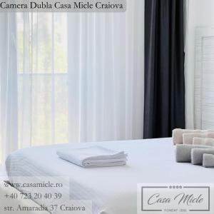 克拉约瓦Casa Micle的白色的床,上面有毛巾