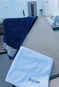 加拉奇科Bella Home的一张白色的床,上面有蓝色的毛巾