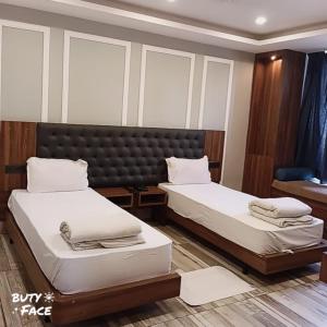 瑞诗凯诗Hotel Trihari的带窗户的客房内设有两张床的房间