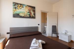斯培西亚Il Cinquecento的卧室配有一张床,墙上挂有绘画作品