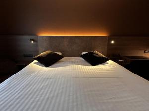 巴斯托涅梅尔巴酒店的一张带两个枕头的大白色床